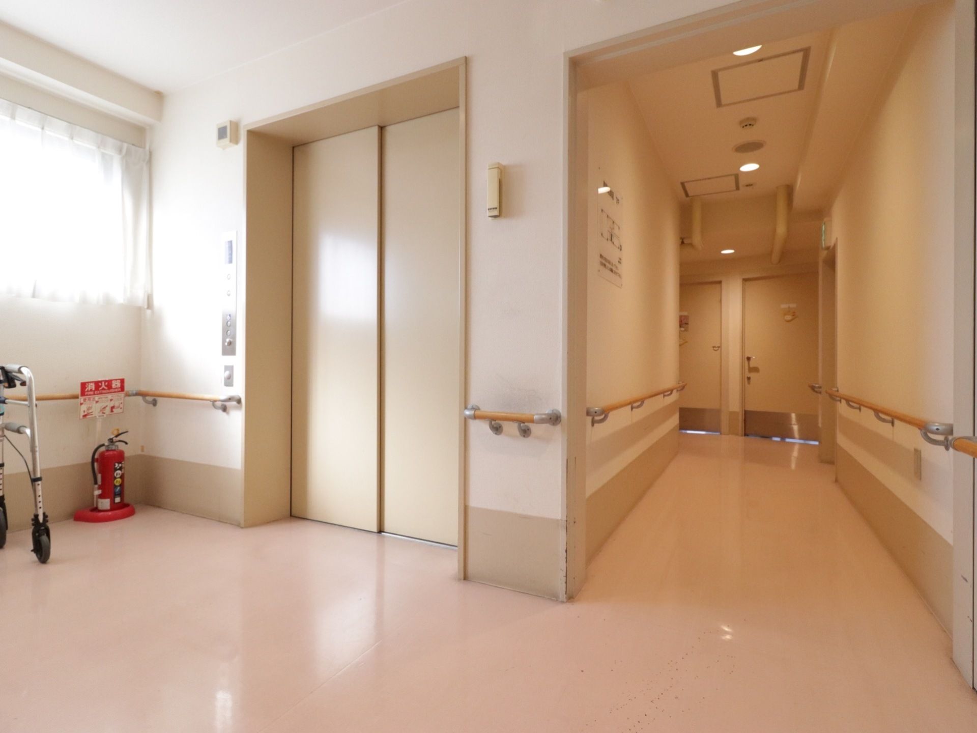 ストレッチャー対応のエレベーター。車椅子の入居者様のためのボタンもある。入り口前は広く手すりもついている。