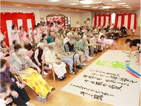 「新道ケアコミュニティそよ風」の10周年記念イベント。施設の記念日を祝い、入居者様も一緒に楽しんでいる。