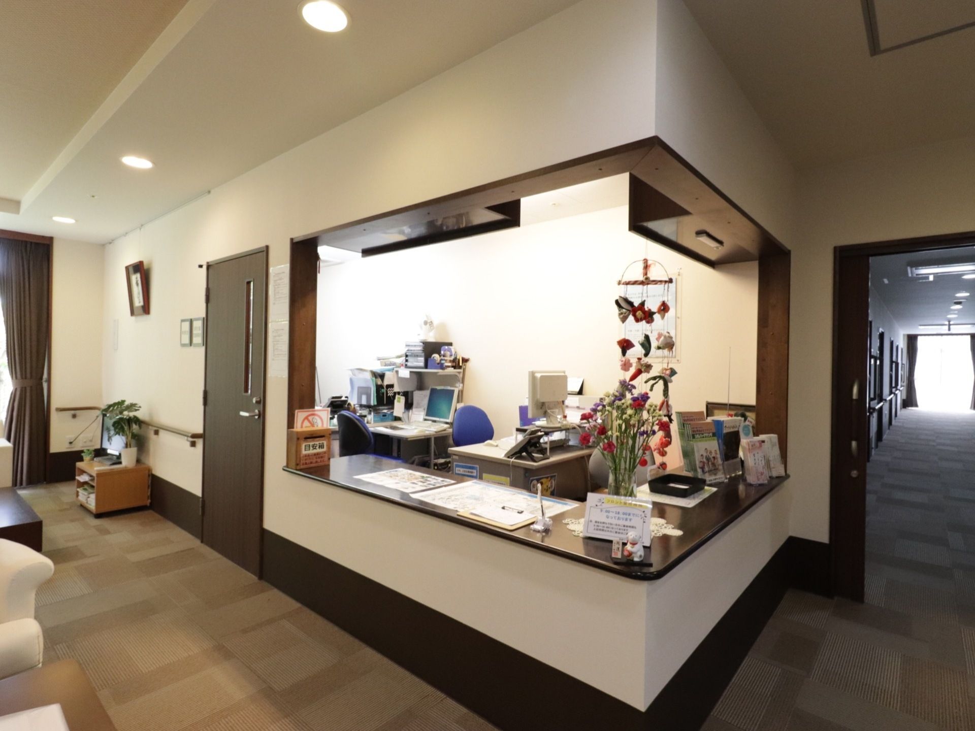 受付カウンター内には職員が常駐するための設備が整っている。眩しさを抑えている入居者用スペースよりも照明が明るい。