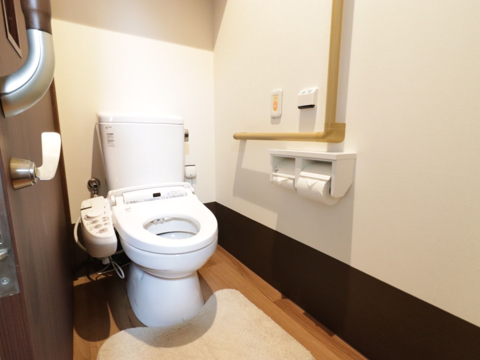 居室備え付けのトイレ。ドアはスライド式で施錠できるようになっている。壁には緊急時用のナースコールがある。