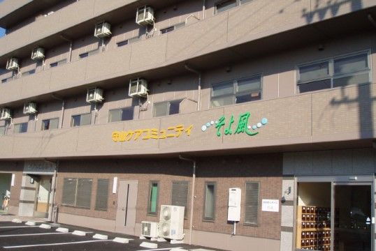 「守山ケアコミュニティそよ風」の外観。複数の車が止められる広い、駐車場。