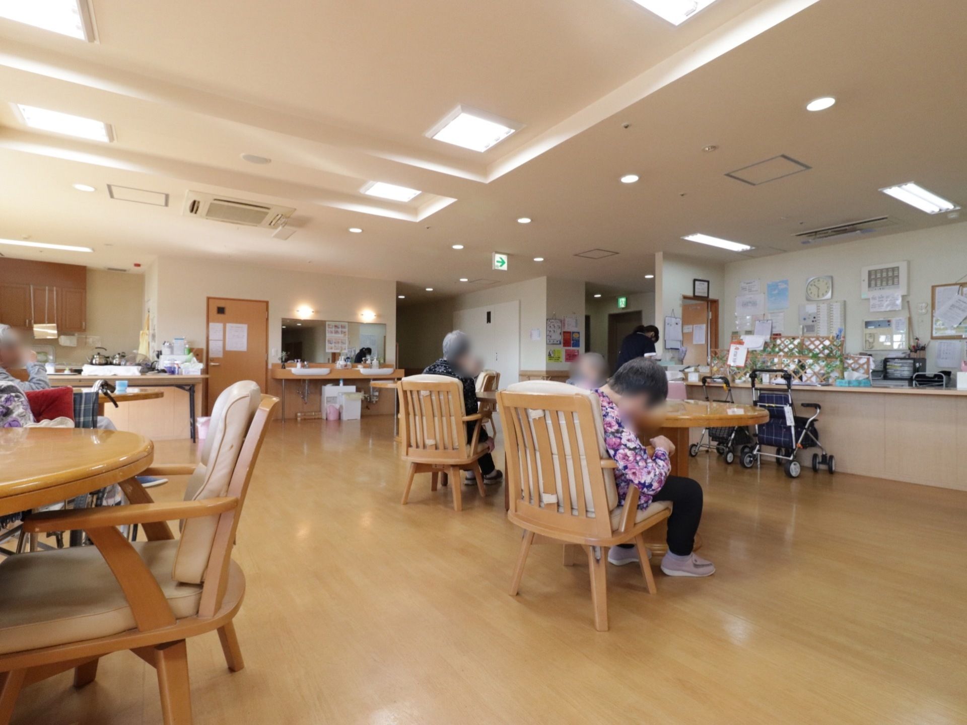 丸テーブルが用意されており、椅子も座面と背面がしっかりとしたクッション性のあるものである。壁際には歩行器が置いてある。