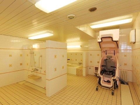浴室には介護用入浴機器が用意されている。横のスペースには洗い場と浴槽がそれぞれ離れた場所に配置されている。