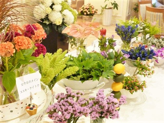 白いテーブルに色とりどりの草花が置かれている。