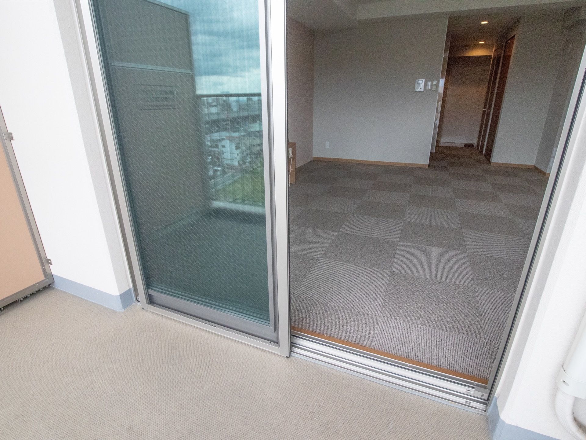 ベランダから居室内へは段差が少ない。窓が大きいので、光が居室内に入ってきやすい。居室内はシンプルで広々とした空間である。