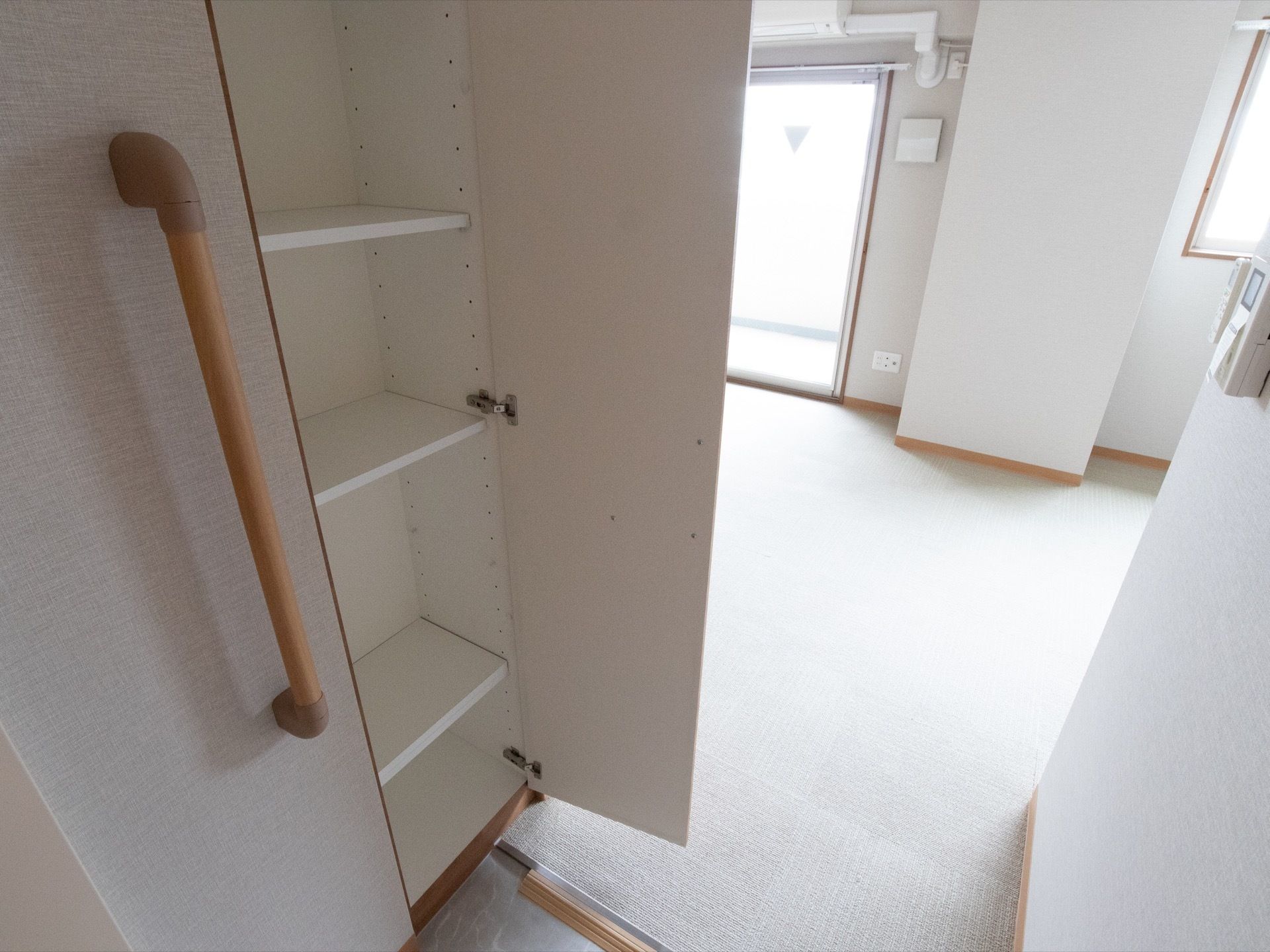 出入口付近にある靴箱の前には縦方向に木製の手すりが設置されており、入居者様は安全に靴を脱ぎ履くすることができる。