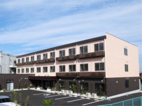 1階はダークブラウン、2、3階はベージュに塗られた外観の建物