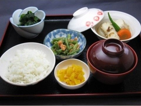 漬物やお浸しの小鉢が並び、煮物と味噌汁が添えられた食事例