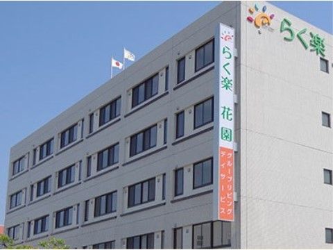 日当たりの良い大きなグループホームである。たくさんの窓が設置されており、屋上部分に旗が２本立てられている。