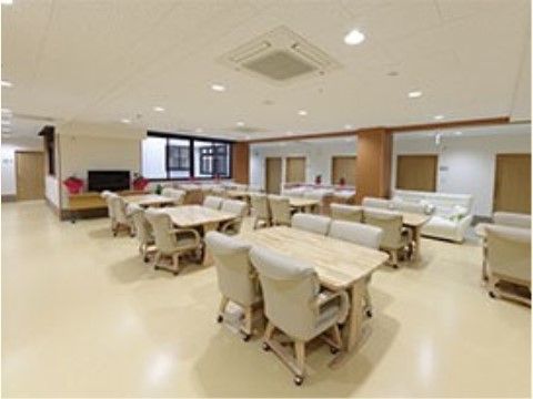 ４人掛けのダイニングテーブルと、キャスター付きのゆったりと座れるひじ掛け付きの椅子が複数置かれている。