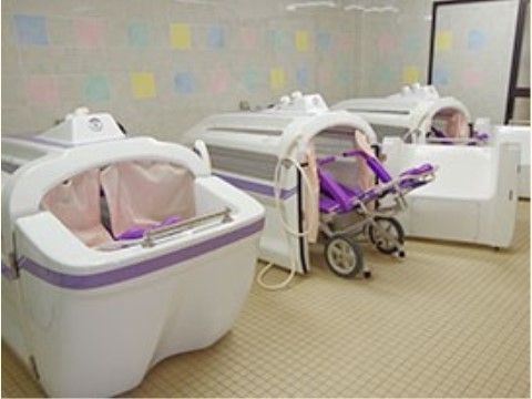介護者が楽な姿勢のまま入浴できる機械浴槽が３つ並んで置かれている。清潔感のあるタイル張りの浴室となっている。