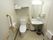 白が基調のトイレで清潔感がある。車いすの方も使いやすい十分なスペースがあり、下にスペースがある洗面台もついているので使いやすい。