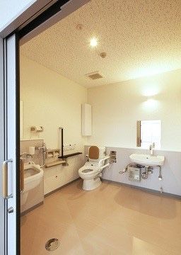 「木場清里苑（特定施設入居者生活介護）」の車椅子対応トイレ。トイレの真横に洗面台を設置することで、体へのダメージを減らしている。