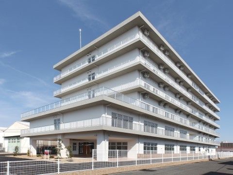 「木場清里苑（特定施設入居者生活介護）」の外観。堀川が近くを流れており、お散歩しやすい7階建ての白いマンション。