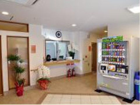 職員が応対する受付カウンターがある。入り口から段差がない広い空間に、観葉植物と胡蝶蘭の鉢植えが置かれている。