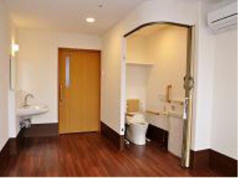 居室ドアは引き戸で、大きな取っ手が付いている。トイレは便座両脇に手すりが付き、アコーディオンカーテンで仕切られている。