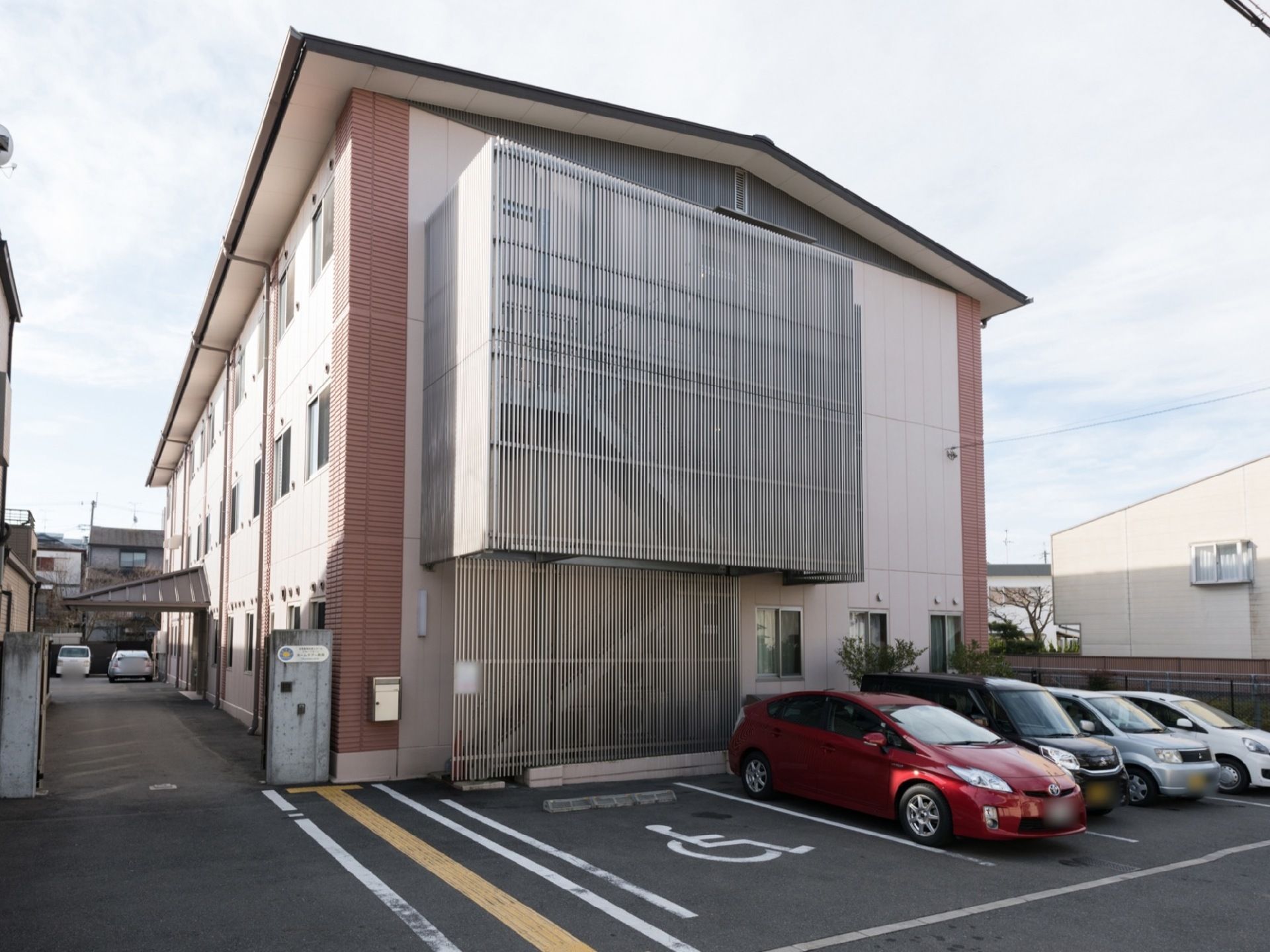 鉄筋コンクリート建ての施設で、道路側の避難階段にはアルミ格子が設置されており、見た目の圧迫感を解消している。