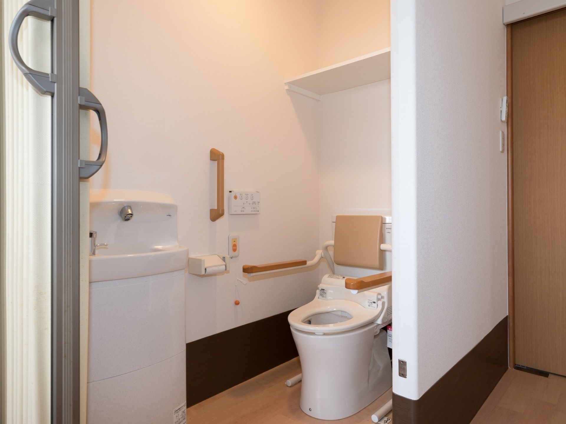 居室に設置されたトイレ。壁とトイレの両側に手すりがある。壁にはナースコールが設置されているため、安全に利用できる。