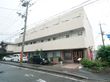 ３階建ての建物で、施設前には歩道がある。２、3階にはベランダがあり、玄関は縦長の明かり取りの窓のある、茶色のドアである。