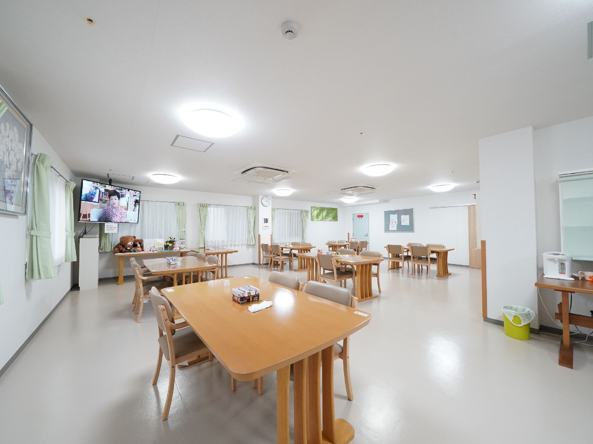 白を基調とした内装に椅子がセットされたテーブルがいくつも並んだ食堂