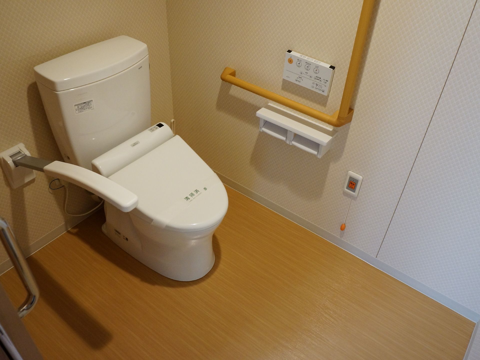 トイレの扉は開け閉めしやすいように、スライド式となっている。また壁には手すりがあり、緊急時の呼び出しボタンが備え付けられている。