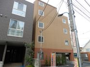 茶色地の壁面の5階建て建物となっている。駐車場は1階にめり込むようにしてあり、最上階は半分がテラスとなっている。