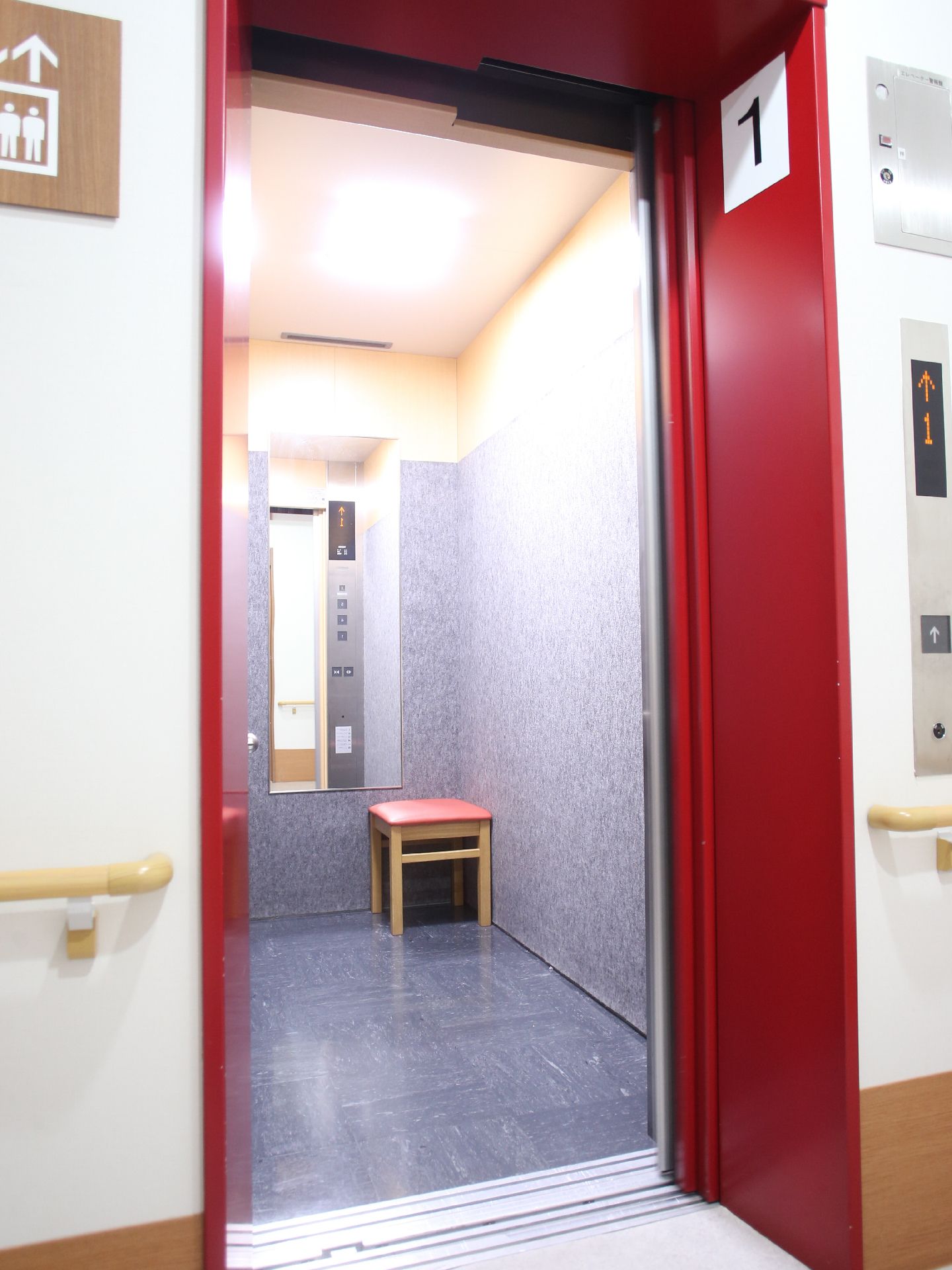 施設内には車イスのままでも乗れる大きなエレベーターの他に、小さなタイプも設置されている。また室内にはイスが置かれている。