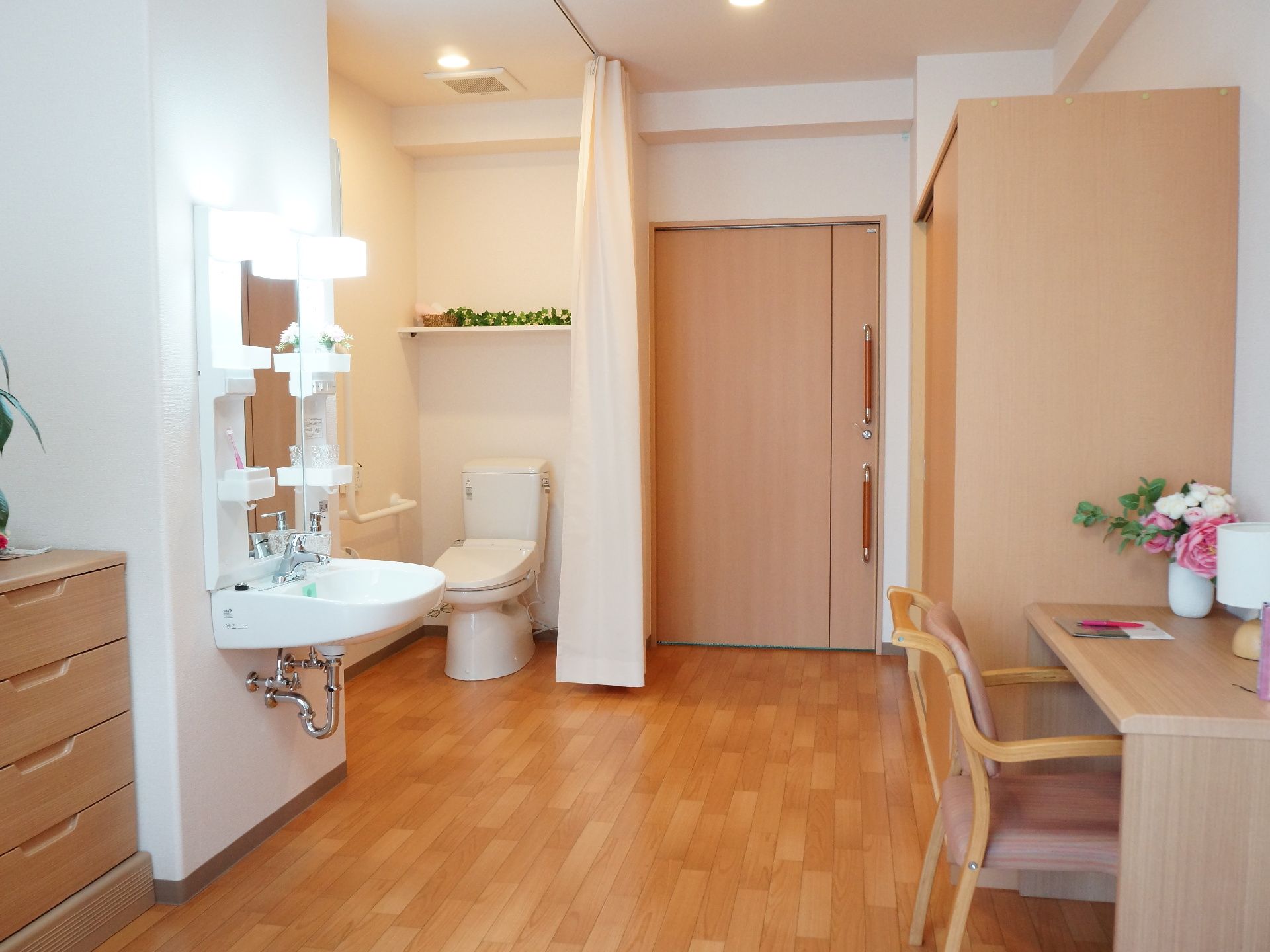 クローゼットや洗面台、テーブルがある。トイレはドアのある個室ではなく、カーテンで仕切れるようなっている。