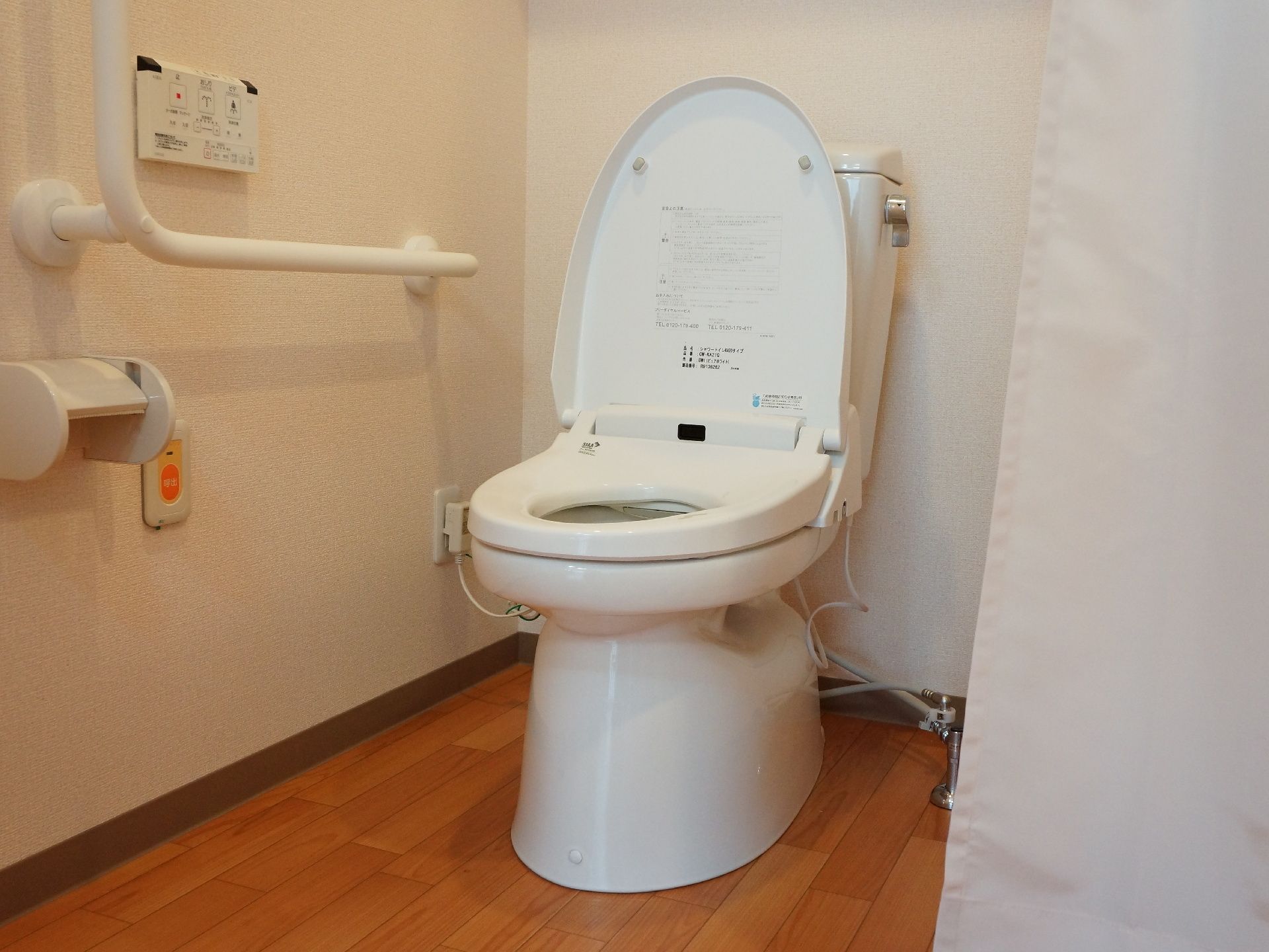 温水洗浄便座の備わったトイレは、カーテンで仕切ることができる。ナースコールや手すりが設置されている。
