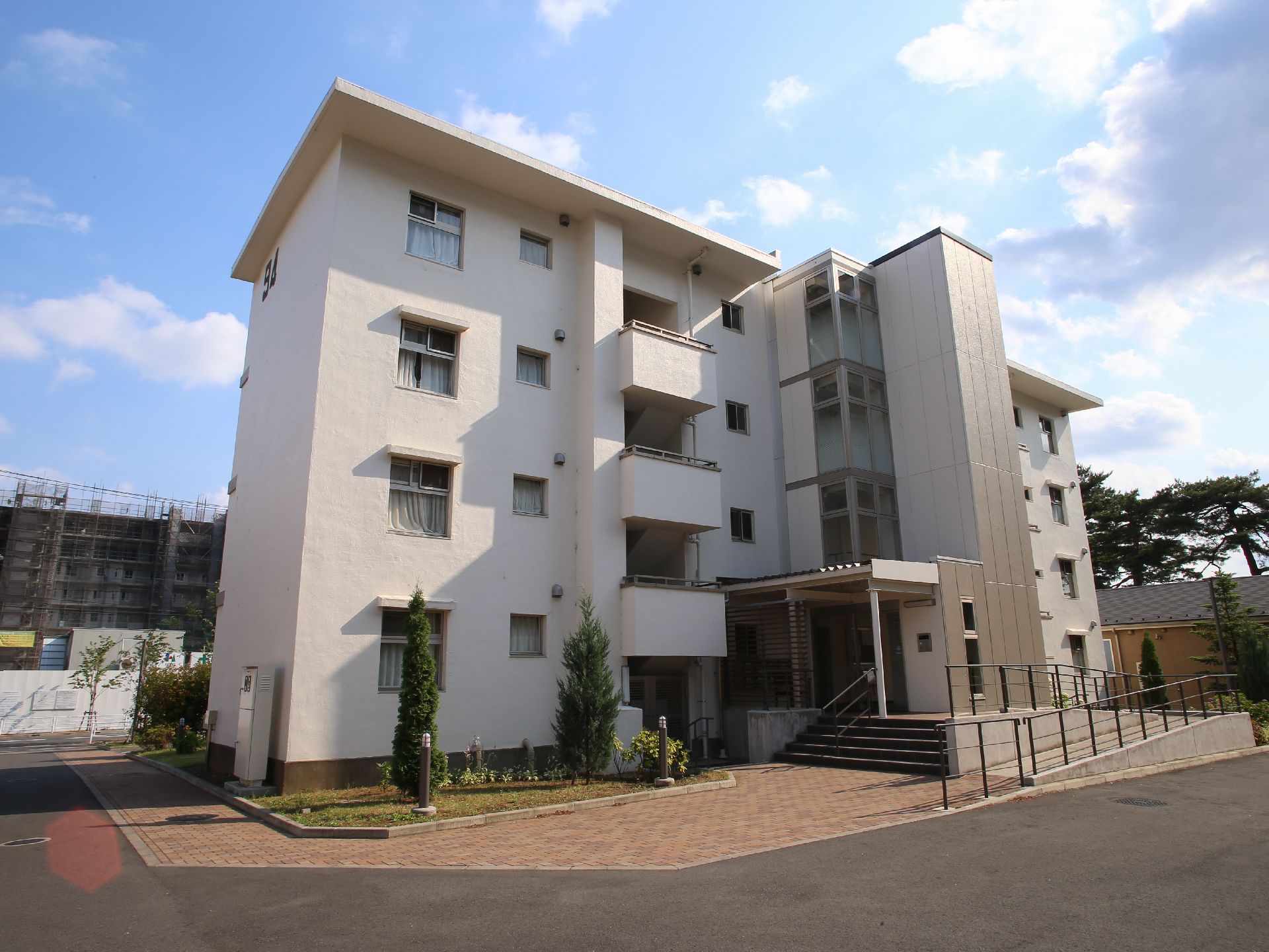 施設は4階建ての白い建物である。壁の近くは植物が植えられており、その外側はタイル敷きになっている。玄関前に階段がある。
