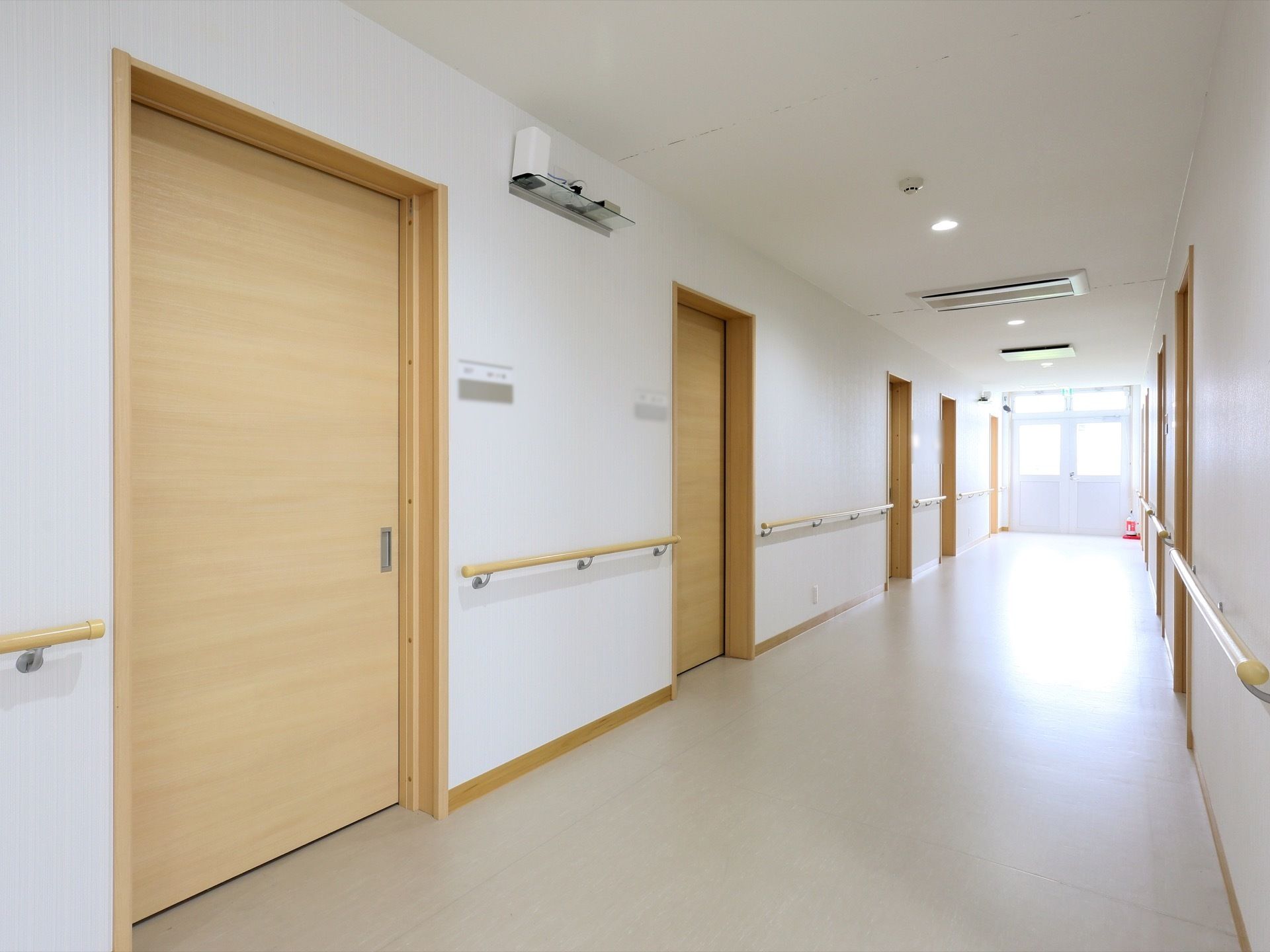外光が差し込む明るい廊下である。天井に埋め込み式のエアコンが設置されており、快適に過ごすことができる。