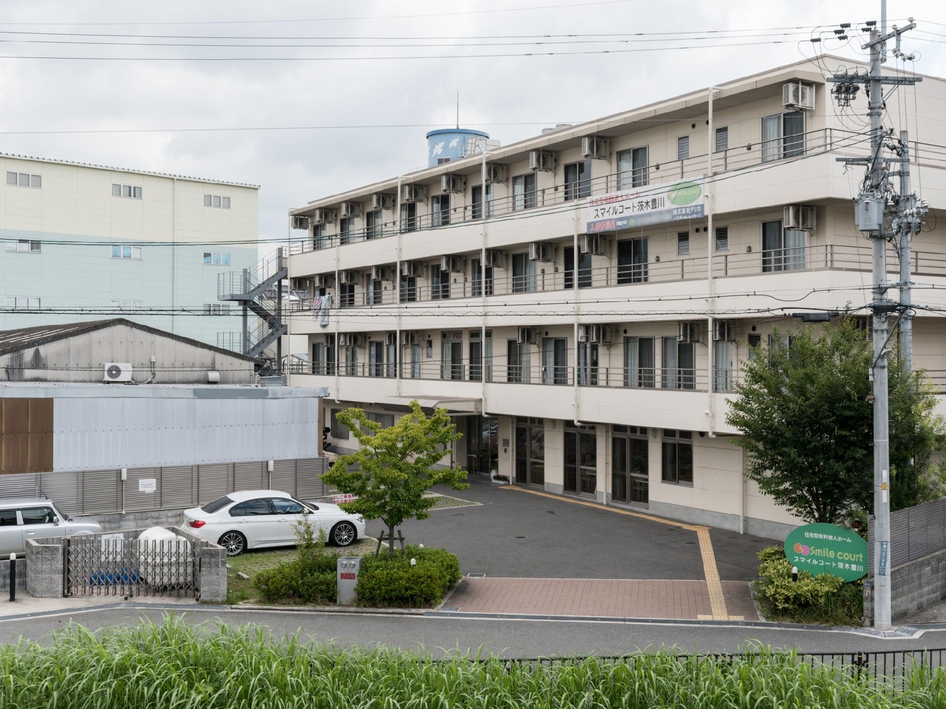 道路沿いに面した敷地内出入口には緑色の看板が掲げてあり、広々としたスペースで車が入りやすくなっている。