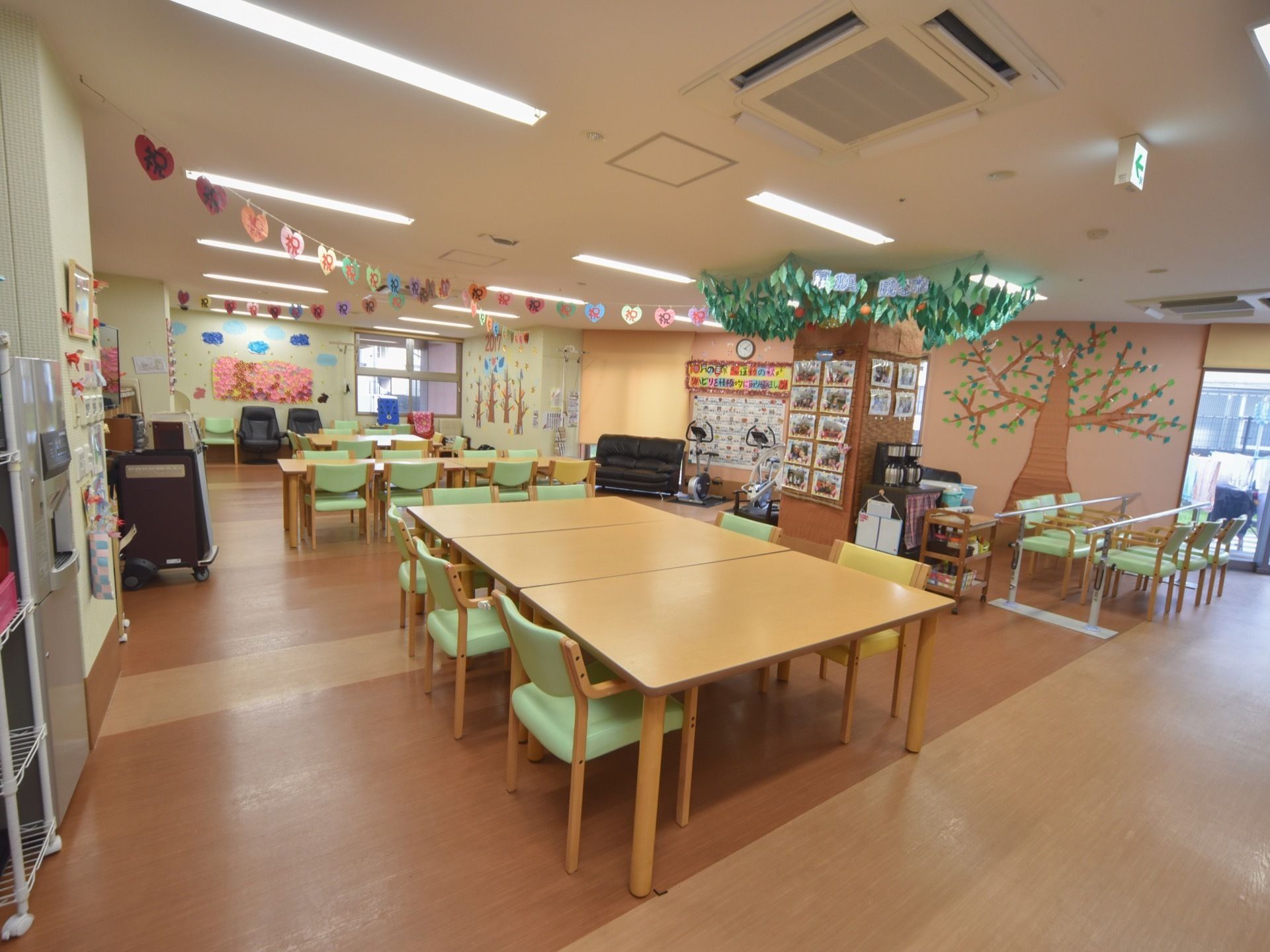 食堂はゆとりのある広さが取られている。食堂の奥には機能訓練用のトレーニングマシンなどが置かれている。