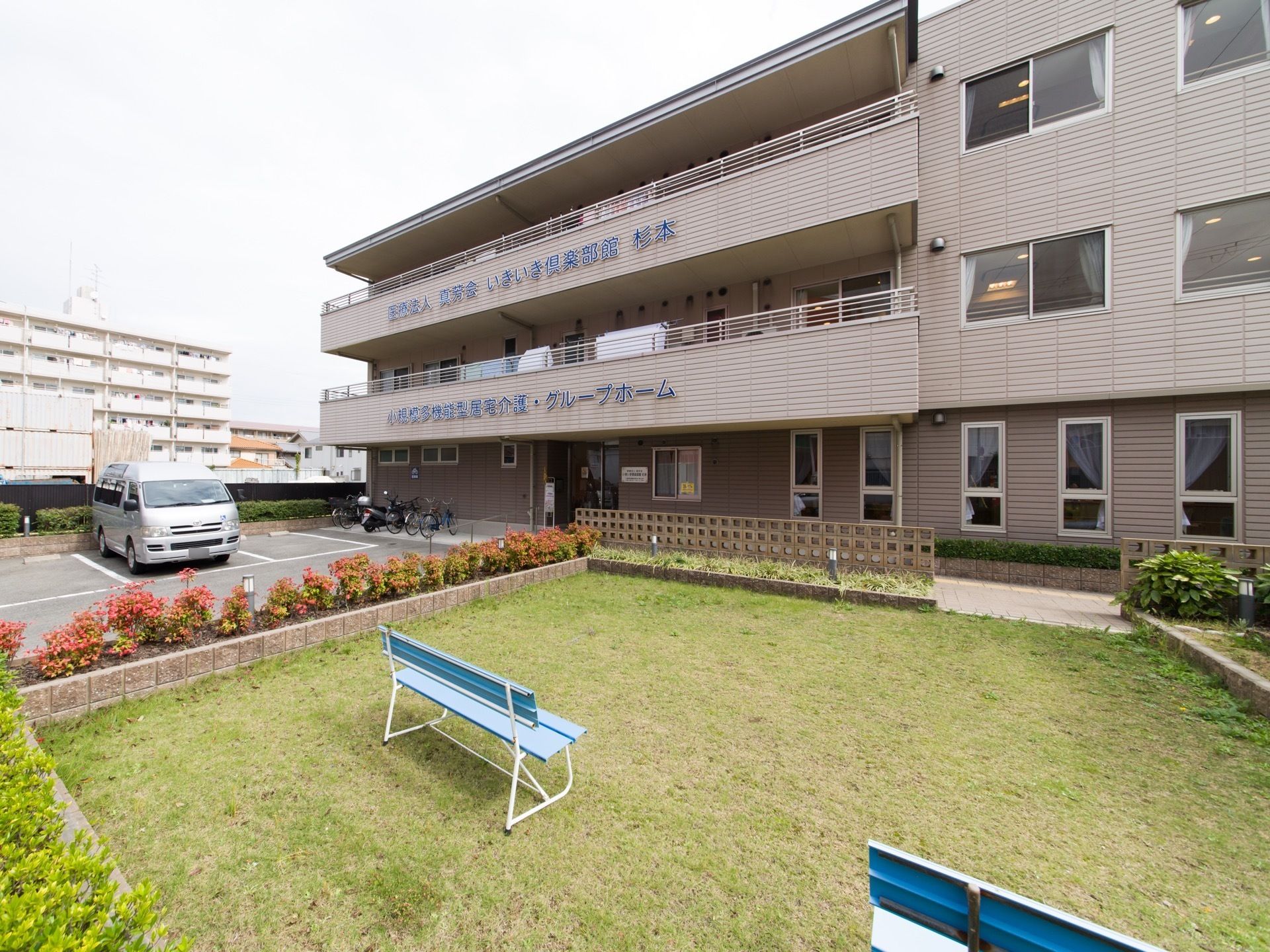エントランスの前には、駐車場や自転車置き場、芝生の広がった庭園が完備されている。高台にあるので見晴らしがよい。