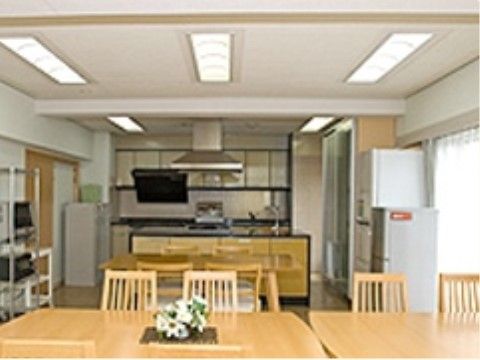アットホームな雰囲気が広がる共有スペースで、毎日の食事やレクリエーションが開催される。冷蔵庫が２台置かれている。