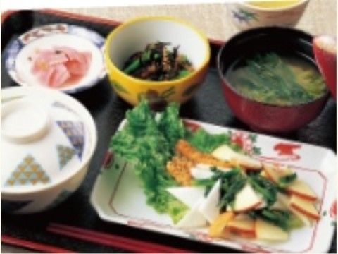 主菜に漬物、小鉢、味噌汁が添えられてお盆に乗っている食事例