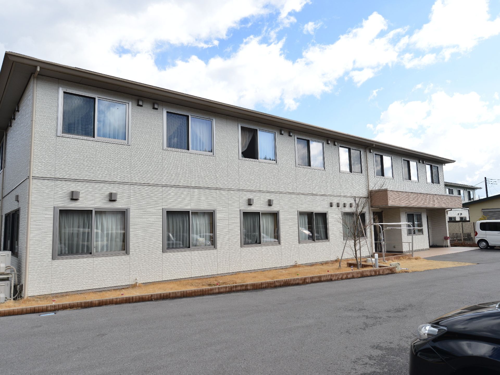 建物は2階建てになっている。目の前は駐車スぺースになっており、とても広々としている。玄関まで車で寄せられるのでとても便利。