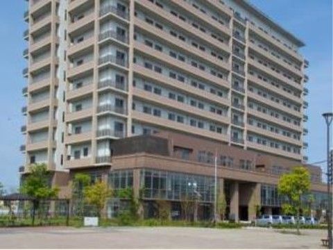 高層マンションのような外観の施設である。ベランダの窓がたくさんあり、施設の周りには木が植えられている。