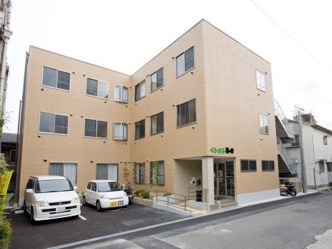 施設を外から見た様子。花壇や植え込みがあり、季節を感じることができる。集合住宅のようなつくりで周囲の住宅街に馴染んでいる。