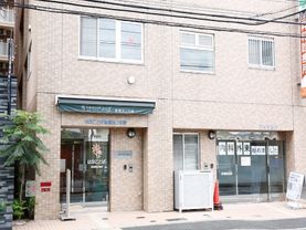 淡い茶色のタイルが組み合わされたような、落ち着いたデザインの外観である。内科外来が、1階の入口横に併設してある。