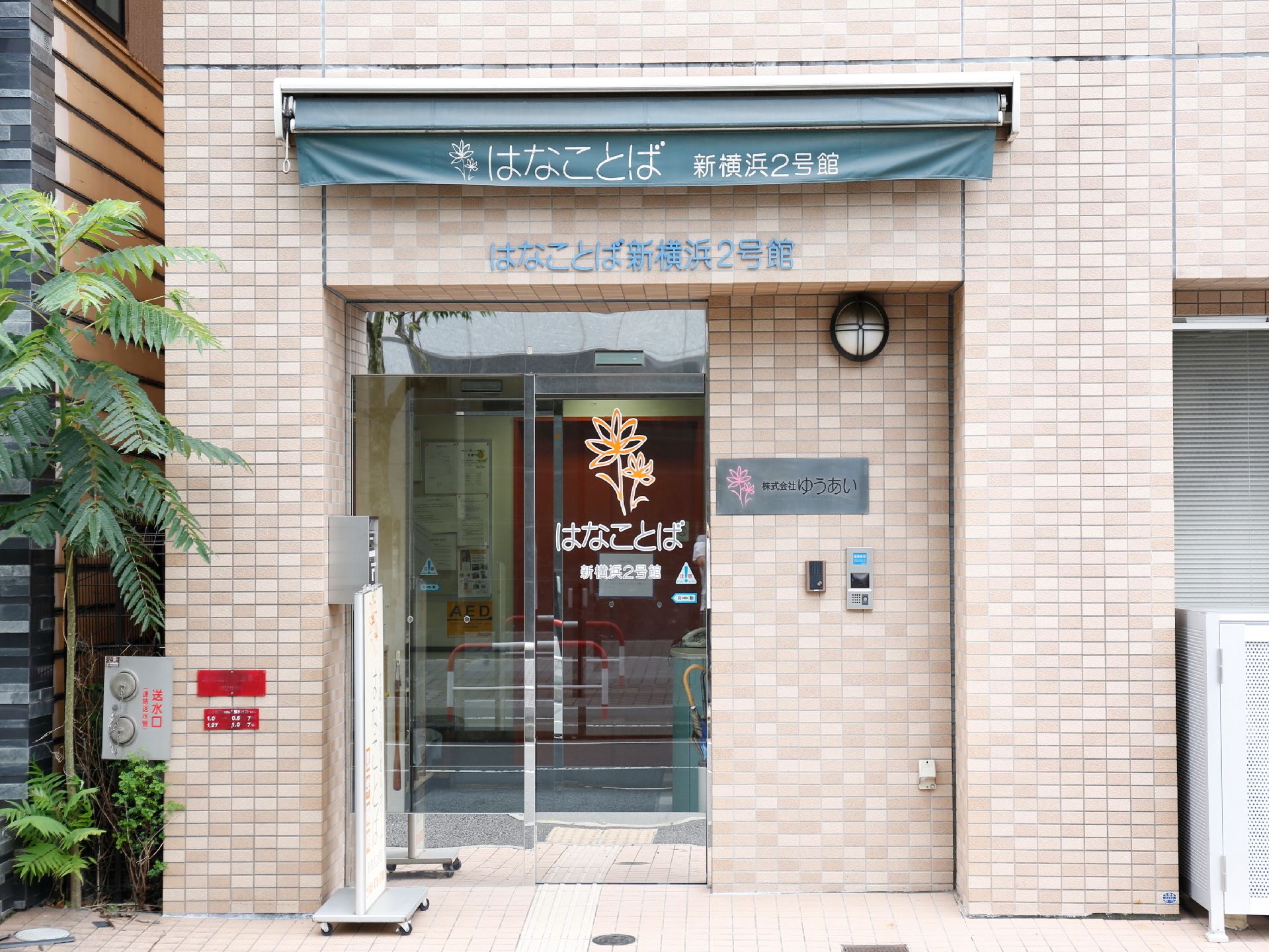 出入口の自動ドアは、透明なガラスになっている。ホーム内にあるオレンジ色のエレベーターのドアが、外からでも確認できる。