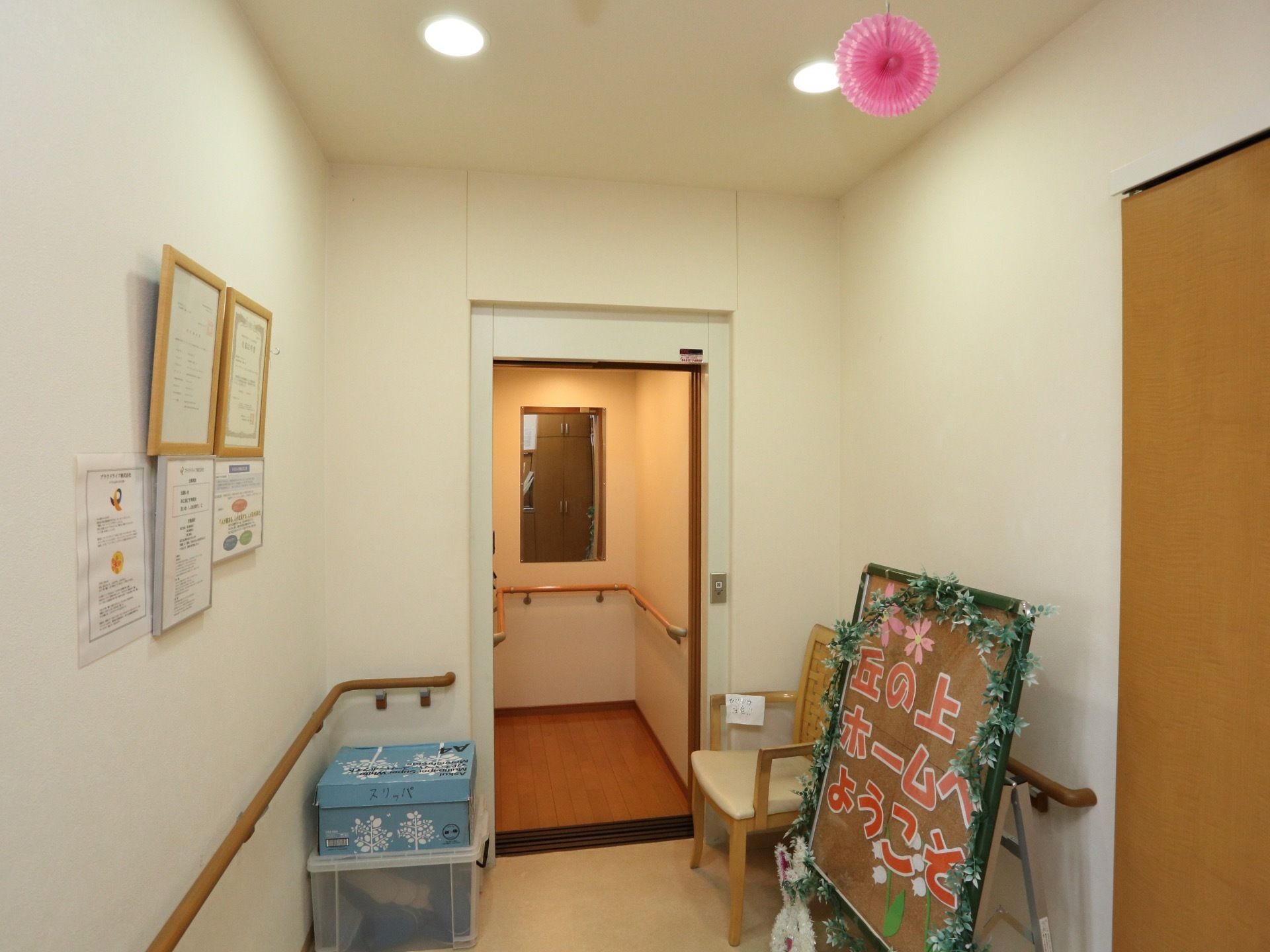 エレベーターの内部にまで手すりがしっかりと備わっている。扉の前には椅子が置かれており、ちょっとした休憩に使用されている。
