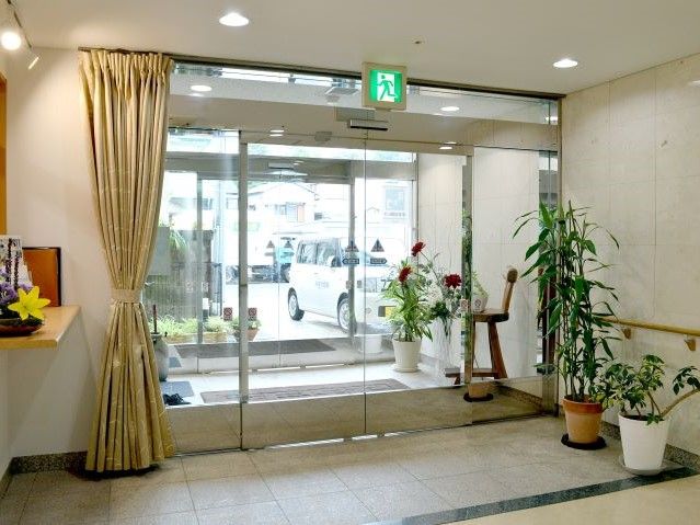 広いエントランスホールには、右側に受付が設けられている。壁際には、ベンチが置かれている。出入口は自動ドアになっている。
