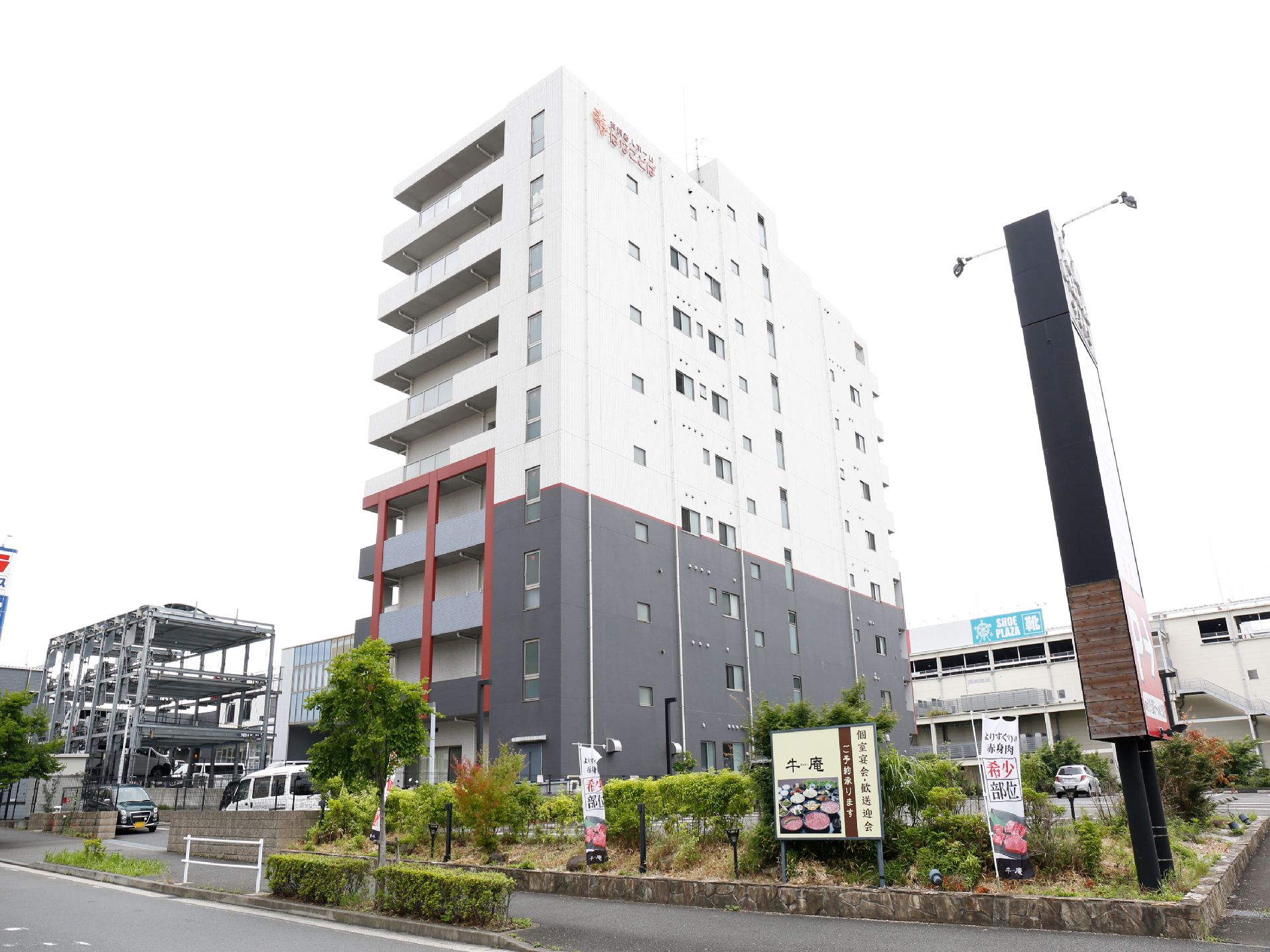 ホームの建物は高いビルになっているが、その最上部の壁面には赤く大きな文字のホーム名の看板が掲げられている。