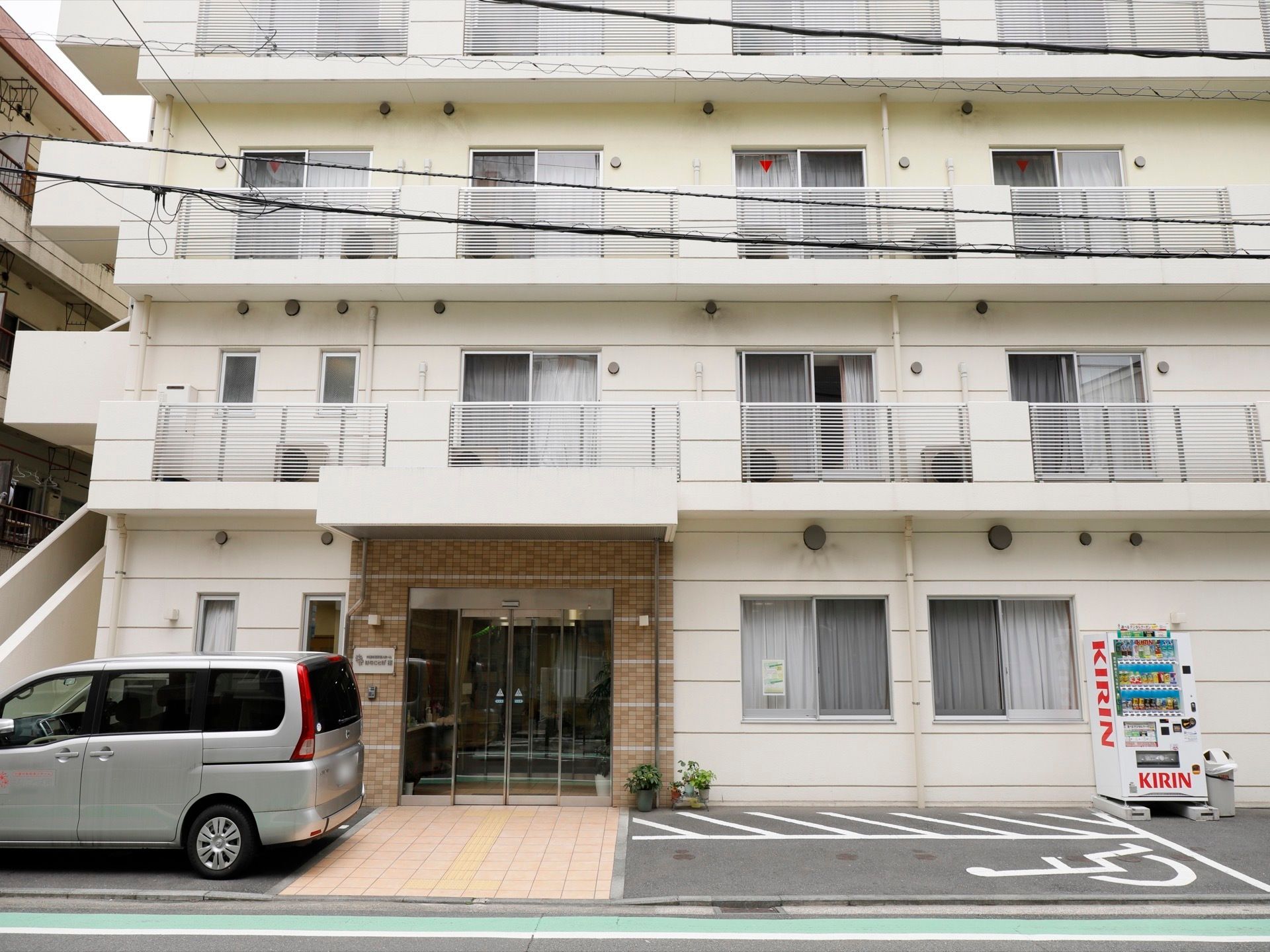 明るい自動ドア方式の正面玄関であり、入居者様の出入りが簡便である。また、通常のお車のほか、車椅子をご利用の方に向けた駐車スペースもある。
