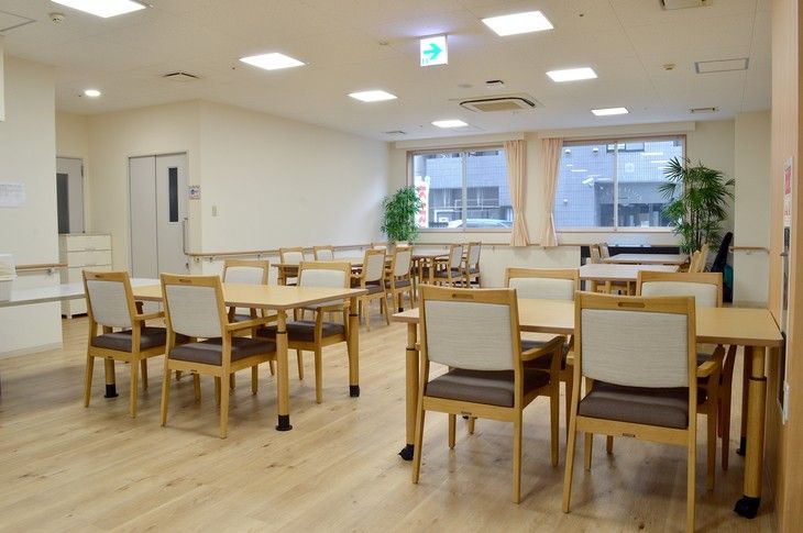多くの入居者様たちが集まって談話をしており、ホームスタッフも明るく対応している。また、テレビや遊具の備え付けがある。