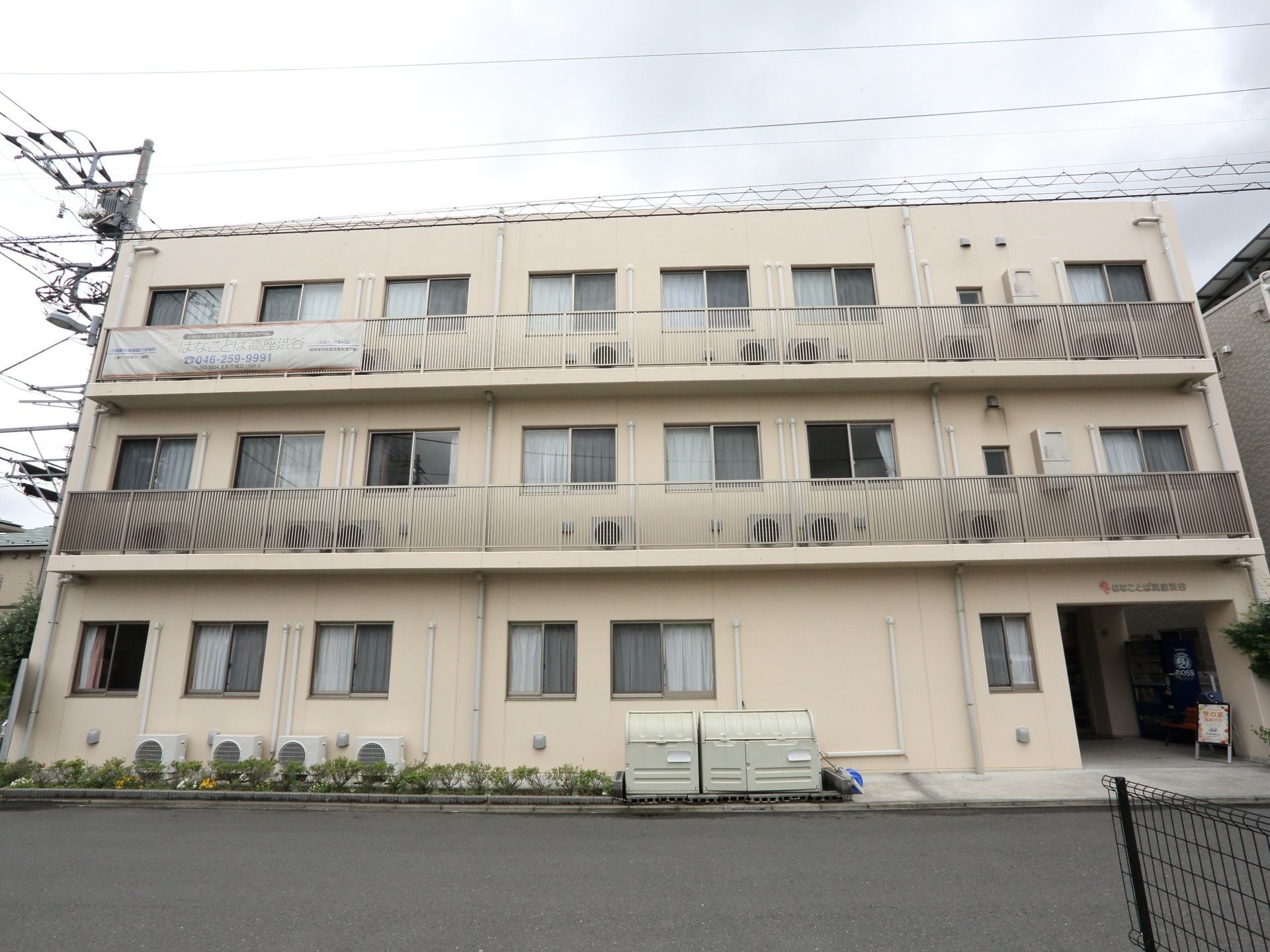 広い入り口と開放的な窓が特徴的な、アイボリーの外壁が美しい外観。目の前は広い道路で、送迎なども楽に行える。