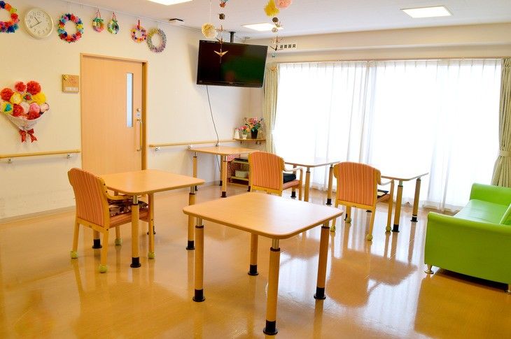 白を基調とした部屋づくりで、大きな窓から明るい光が差している。壁は折り紙などで装飾されており、あたたかい雰囲気である。