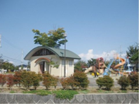 敷地の端に背が低い木が植えられた公園はトイレがあり、その奥にはいろいろな遊具がある。更に奥には大きなケヤキや桜の木が見える。