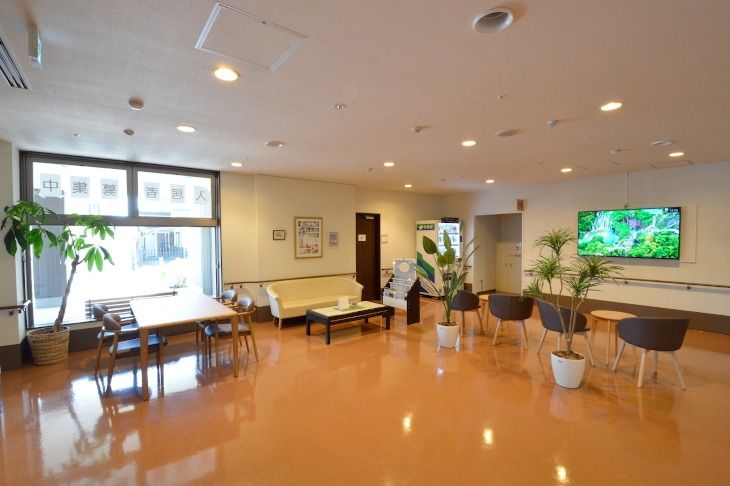 白色の天井に焦げ茶色の外壁で、広々としたガラス張りの出入口になっている。玄関出入口の横には傘立てが置かれ、上部にはホーム名が表示されている。